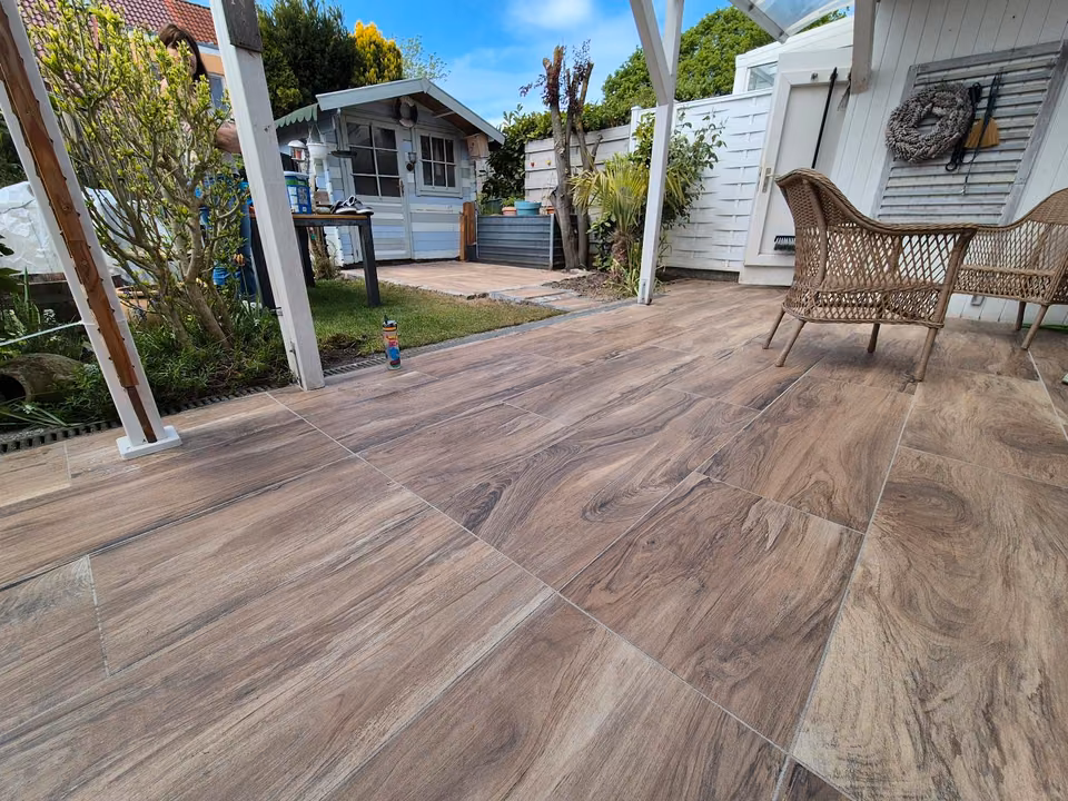 Terrasse mit Belag in Holzoptik vor einem Gartenhaus