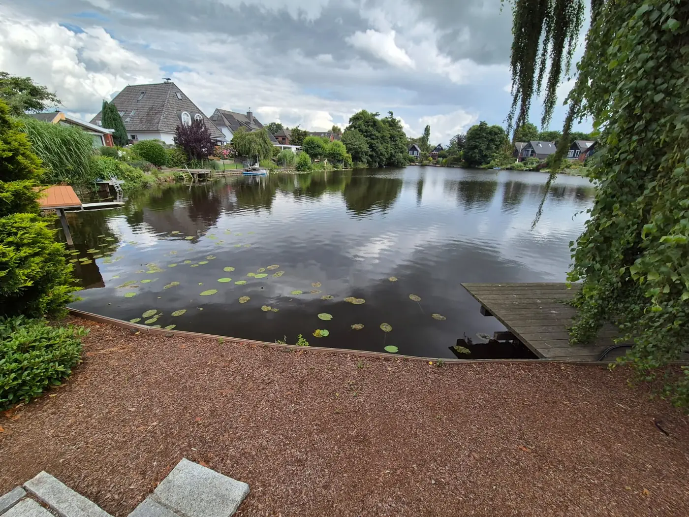 Neu gestaltete Uferfläche mit Splitt und Bepflanzung am Teich