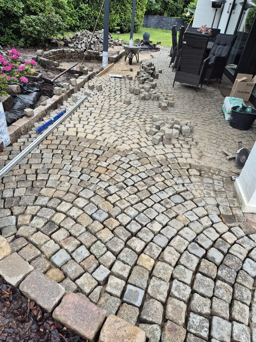 Terrasse aus Natursteinpflaster im Bogenverband, neu gesetzt